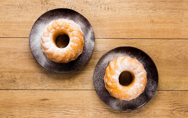 Flache Lage von zwei Tellern mit Donuts