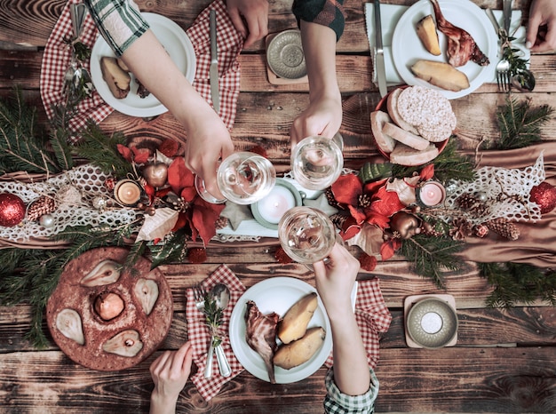 Flache Laien von Freunden, die zusammen essen und trinken. Draufsicht der Leute, die Party haben, sich versammeln, zusammen am rustikalen hölzernen Tisch feiern