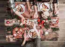 Kostenloses Foto flache laien von freunden, die zusammen essen und trinken. draufsicht der leute, die party haben, sich versammeln, zusammen am rustikalen hölzernen tisch feiern