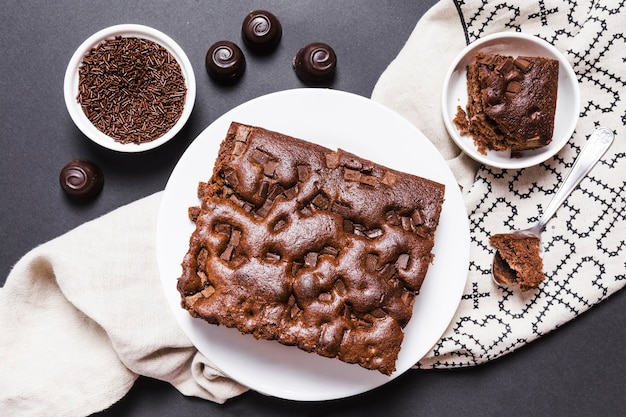 Flache Laienanordnung mit Schokoladenkuchen und Süßigkeiten