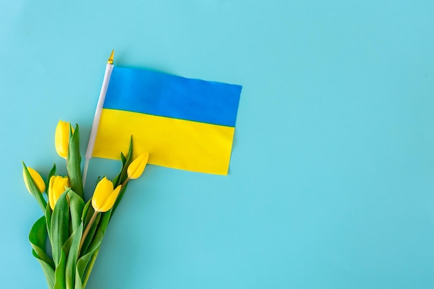 Flache Laienkomposition mit einem Strauß gelber Tulpen die Flagge der Ukraine