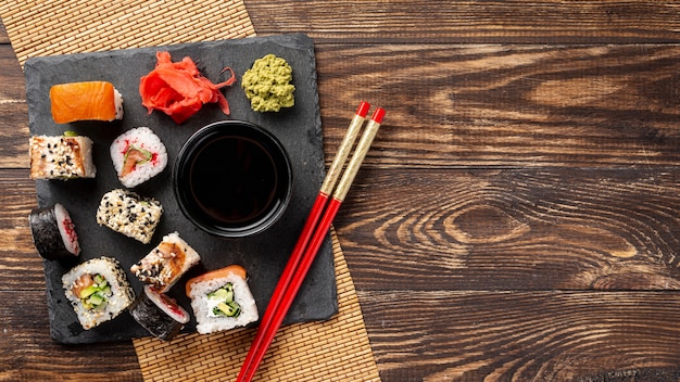 Flache Laienmischung von maki Sushirollen und Essstäbchen mit Kopienraum