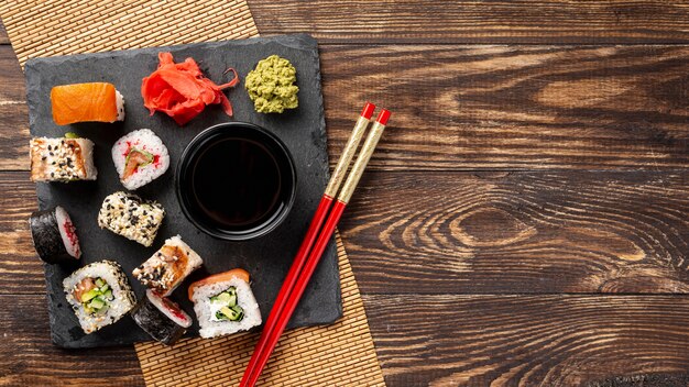 Flache Laienmischung von maki Sushirollen und Essstäbchen mit Kopienraum