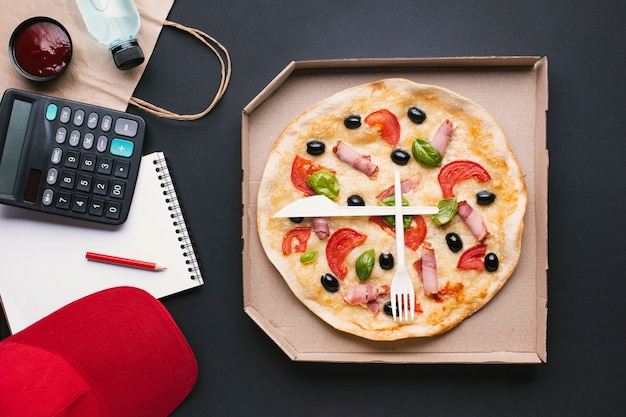 Flache Laienpizza in einer Box mit Taschenrechner