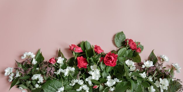 Flache Laienzusammensetzung mit frischen Blumen auf rosafarbenem Hintergrund.
