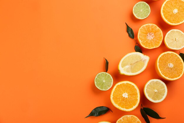 Flache Lay-Komposition mit Mandarinen und verschiedenen Zitrusfrüchten auf orangefarbenem Hintergrund Platz für Text