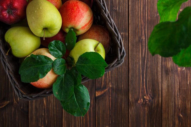 Flache legen Äpfel in Box mit Blättern auf Holzhintergrund. horizontaler Raum für Text