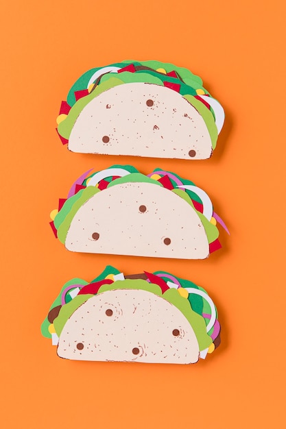 Flache Papier-Tacos auf orangefarbenem Hintergrund