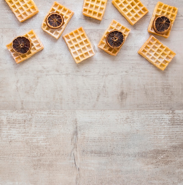 Kostenloses Foto flache waffellage mit getrockneten zitrusfrüchten und kopierraum