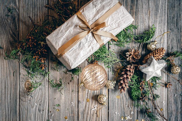 Flache Weihnachtskomposition mit Geschenkbox auf einer Holzoberfläche