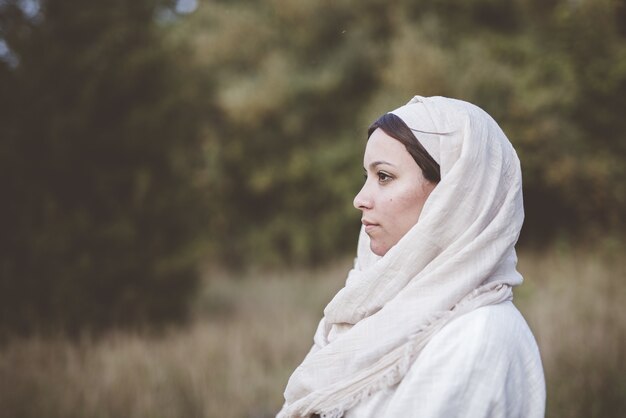 Flacher Fokusschuss einer Frau, die ein biblisches Gewand trägt und in die Ferne schaut