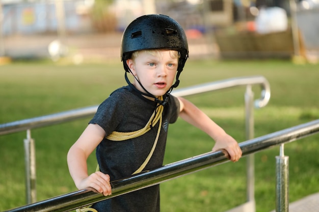 Flacher Fokusschuss eines kleinen Jungen mit einem schwarzen Helm, der in eine Richtung schaut