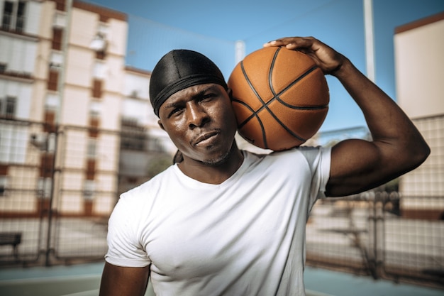 Flacher fokusschuss eines schwarzen basketballspielers in einem innenhof im freien