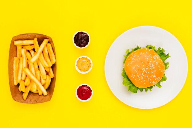 Flacher Hamburger mit Pommes und Saucen