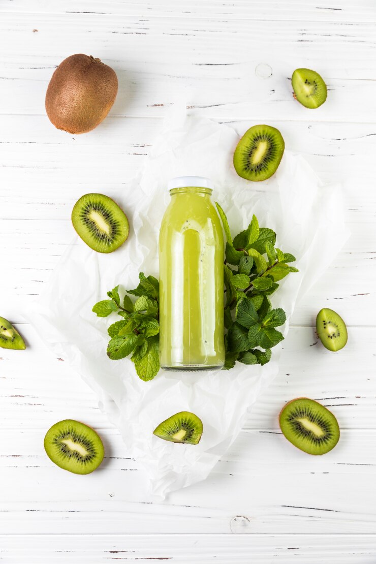 Kostenlose Foto flacher lagekiwi smoothie auf weißem holztisch
