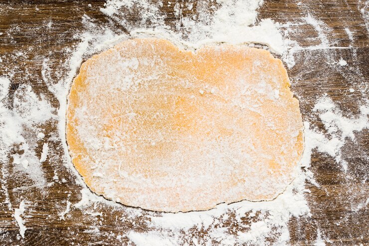 Kostenlose Foto flacher teig mit weißmehl auf holzoberfläche