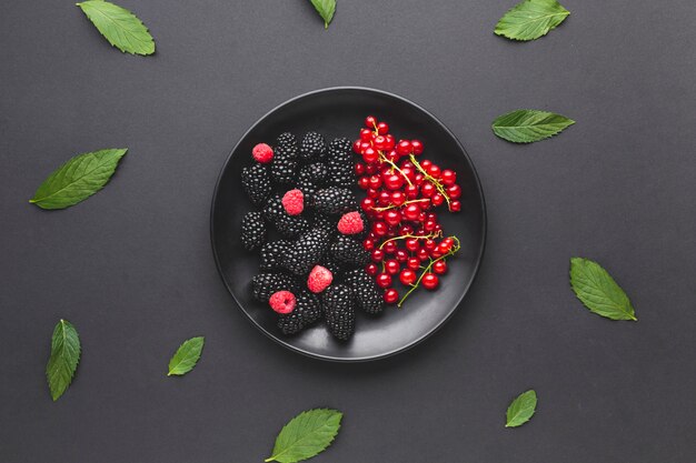 Flacher Teller mit frischen Beeren mit Blättern