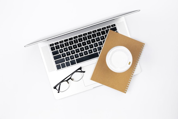 Flacher weißer Hintergrund mit Laptop-Notebook-Kaffeetasse und Gläsern