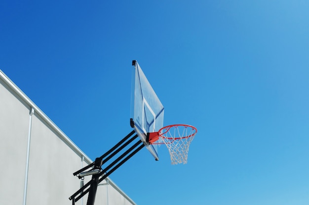 Flacher Winkelschuss eines Basketballkorbs unter dem schönen klaren Himmel