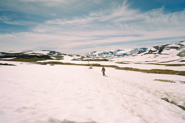 Flacher Winkelschuss eines Mannes, der auf schneebedeckten Hügeln geht