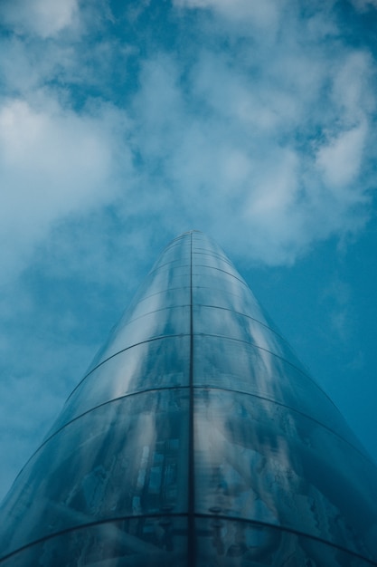 Flacher Winkelschuss eines Turms in Oslo Norwegen, der den bewölkten blauen Himmel reflektiert