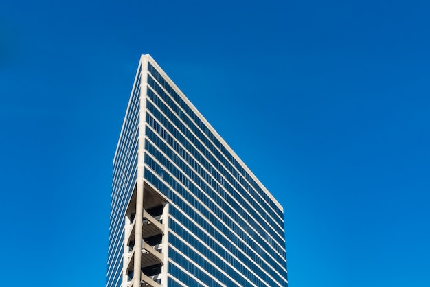 Flacher Winkelschuss von hohen Glasgebäuden unter einem bewölkten blauen Himmel