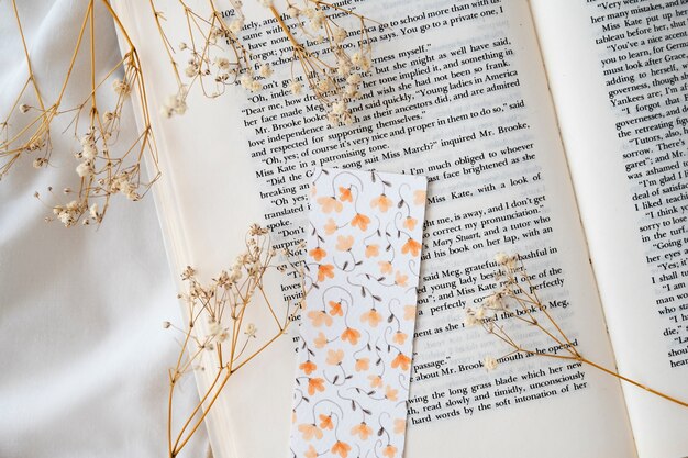 Flaches florales Lesezeichen auf Buch