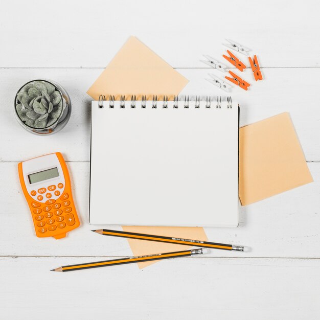 Flaches Notebook-Modell, umgeben von orangefarbenen Vorräten