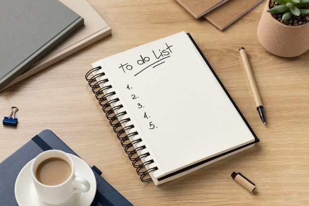 Flaches Notizbuch mit Aufgabenliste auf dem Schreibtisch
