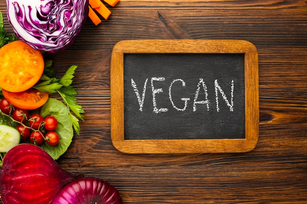 Flachlagegemüsegesteck mit veganer beschriftung auf tafel