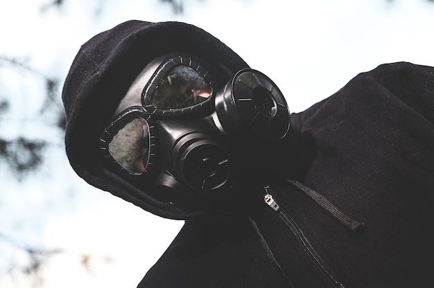 Kostenloses Foto flachwinkelaufnahme einer person, die eine gasmaske und eine schwarze jacke in der ranch während einer quarantäne trägt