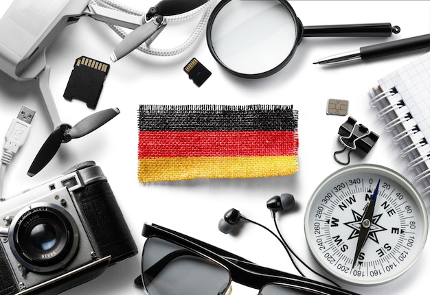 Flagge von deutschland und reisezubehör auf weiß, draufsicht Premium Fotos