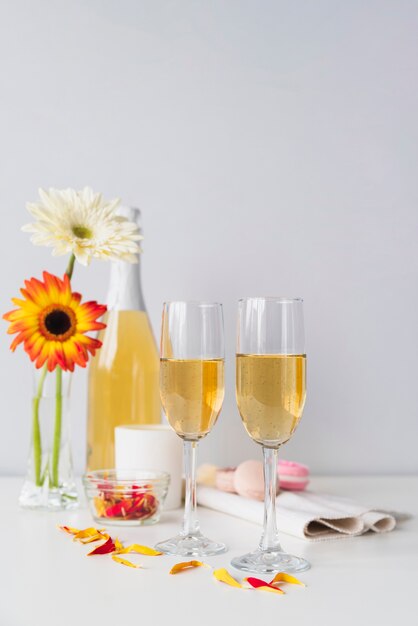 Flasche Champagner mit Gläsern und Blumen