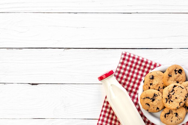 Flasche Milch und Plätzchen auf einer Draufsicht des hölzernen Hintergrundes