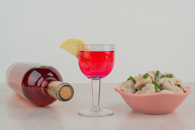 Flasche mit Glas Limonade und Knödelteller.