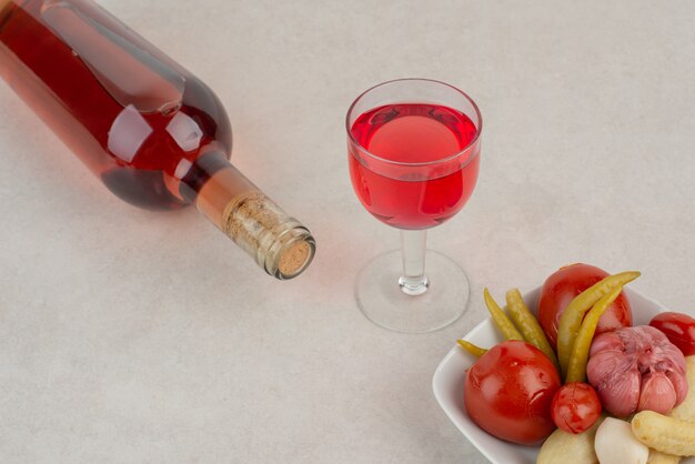 Flasche mit Glas Limonade und Teller Salz Tomate, Knoblauch.