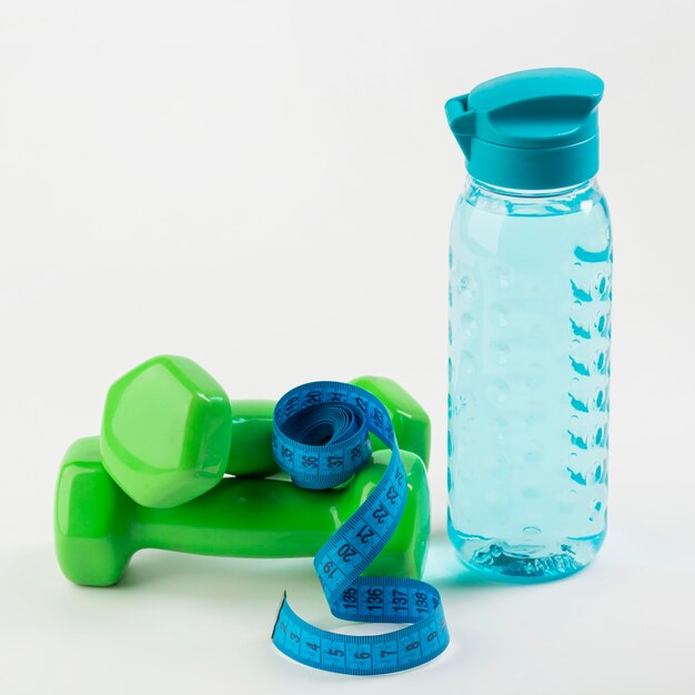 Flasche Wasser mit blauem Zentimeter und Gewichten
