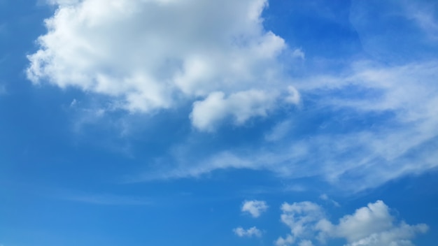 Flaumige Wolken im Hintergrund des blauen Himmels