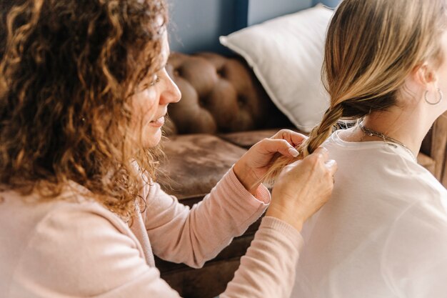 Flechtendes Haar der Mutter der unerkennbaren Tochter