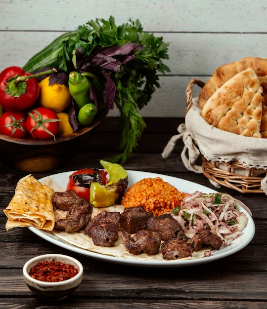 Fleisch Bulgur und Zwiebel mit Sumach auf einem Holztisch