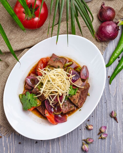 Fleisch mit Gemüse Zwiebel Tomate Petersilie Pfeffer Draufsicht