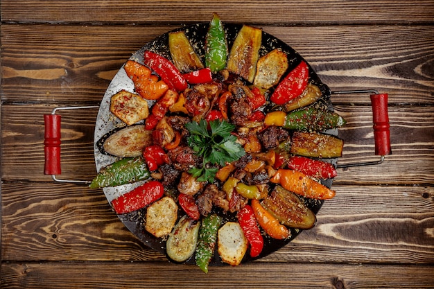 Fleisch Salbei mit Kartoffeln Paprika und Auberginen auf Holzkohle Draufsicht gekocht