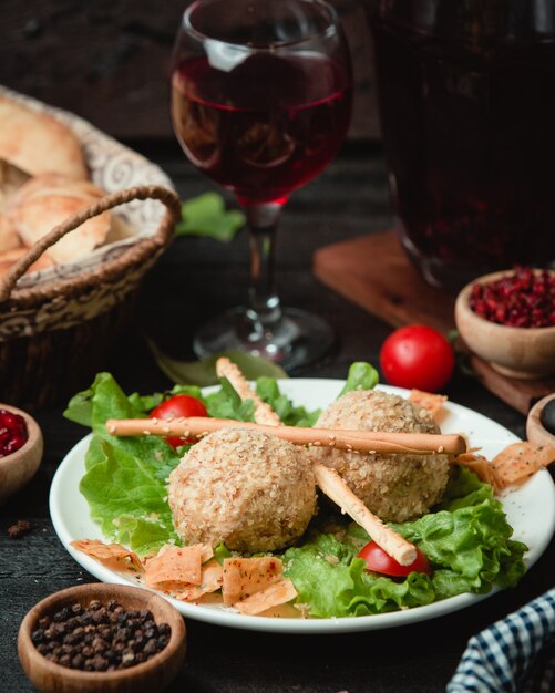 Fleischbällchen mit Galettastangen und Glas Rotwein.