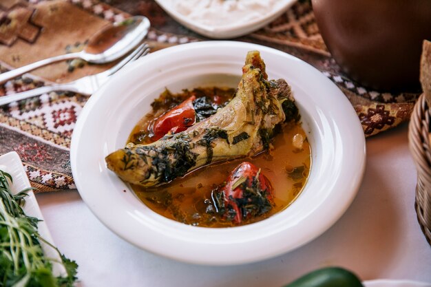 Fleischeintopf in Brühe mit Kräutern und Tomaten.