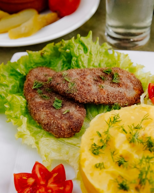 Kostenloses Foto fleischkoteletts mit kartoffelpüree seitenansicht