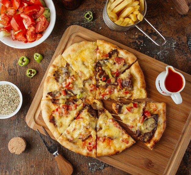 Fleischpizza mit Draufsicht der Pommes-Frites