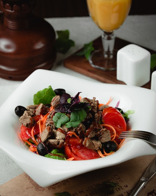 Kostenloses Foto fleischsalat mit tomaten, oliven und kräutern