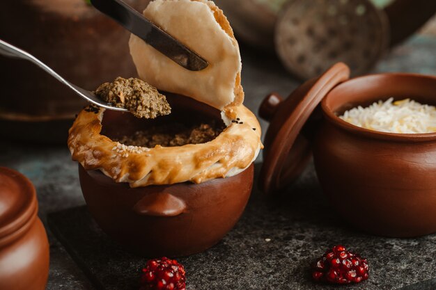 Fleischtorte gebacken innerhalb der Tonwarenschüssel, Fleisch nehmend