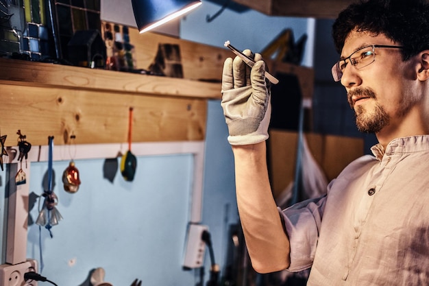 Fleißiger, fokussierter Meister sucht nach dem richtigen Glas für sein Projekt.