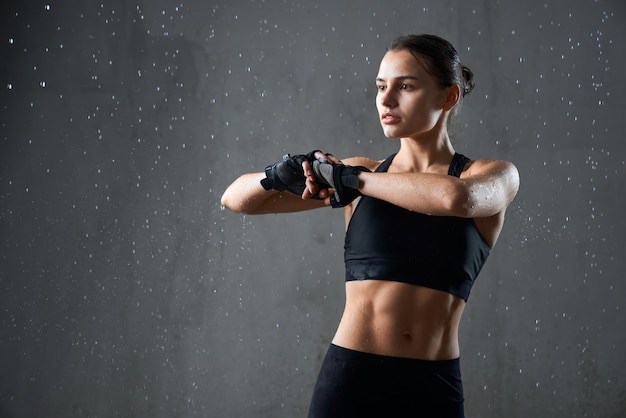 Flexible Fitnessfrau, die Arm vor dem Training streckt